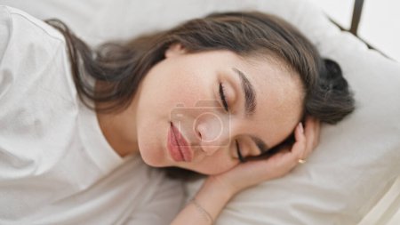Téléchargez les photos : Jeune belle femme hispanique couchée sur le lit dormant dans la chambre - en image libre de droit