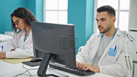 Téléchargez les photos : Médecins hommes et femmes utilisant l'ordinateur prenant des notes de travail à la clinique - en image libre de droit