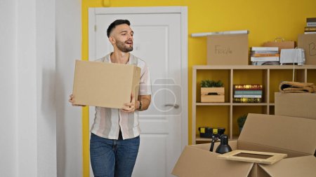 Photo for Young hispanic man smiling confident holding package at new home - Royalty Free Image