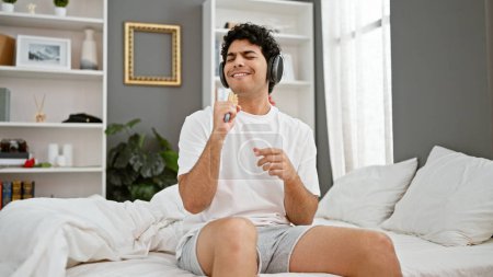 Foto de Joven latino escuchando música cantando en el dormitorio - Imagen libre de derechos