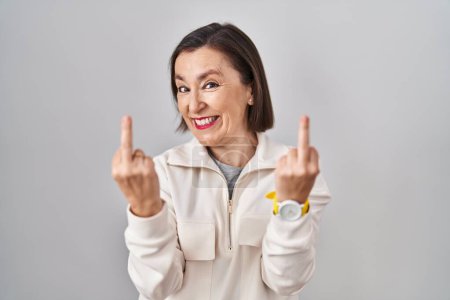 Foto de Middle age hispanic woman standing over isolated background showing middle finger doing fuck you bad expression, provocation and rude attitude. screaming excited - Imagen libre de derechos