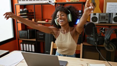 Téléchargez les photos : Femme musicienne afro-américaine écoutant de la musique danser au studio de musique - en image libre de droit