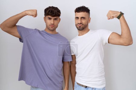 Photo for Homosexual gay couple standing over white background strong person showing arm muscle, confident and proud of power - Royalty Free Image