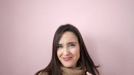 Téléchargez les photos : Belle femme hispanique souriante confiante debout sur fond rose isolé - en image libre de droit