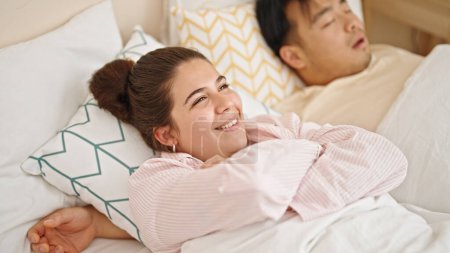 Téléchargez les photos : Couple homme et femme couché sur le lit souriant à la chambre - en image libre de droit