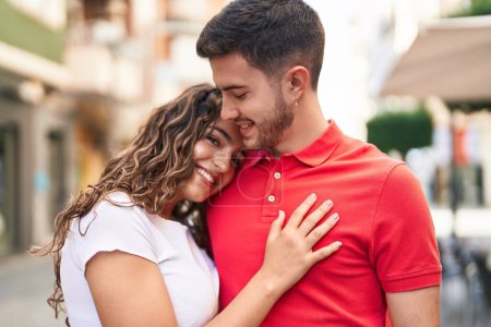 Photo for Young hispanic couple smiling confident hugging each other at street - Royalty Free Image