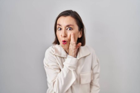 Photo for Middle age hispanic woman standing over isolated background hand on mouth telling secret rumor, whispering malicious talk conversation - Royalty Free Image