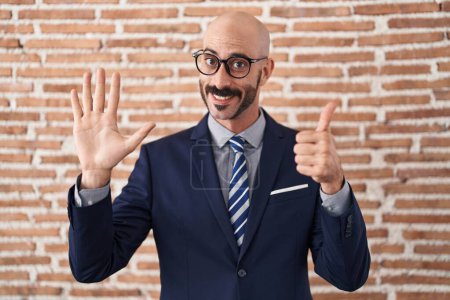 Photo for Bald man with beard wearing business clothes and glasses showing and pointing up with fingers number six while smiling confident and happy. - Royalty Free Image