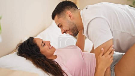 Téléchargez les photos : Homme et femme couple couché sur le lit se regardant dans la chambre - en image libre de droit