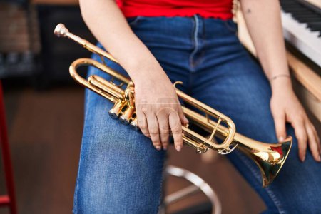 Téléchargez les photos : Young woman musician holding trumpet at music studio - en image libre de droit