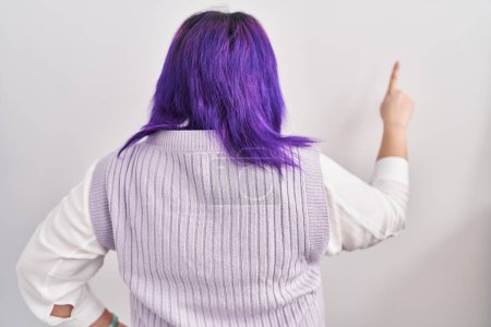 Photo for Plus size woman wit purple hair standing over white background posing backwards pointing ahead with finger hand - Royalty Free Image