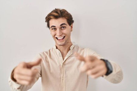 Photo for Young man standing over isolated background pointing fingers to camera with happy and funny face. good energy and vibes. - Royalty Free Image