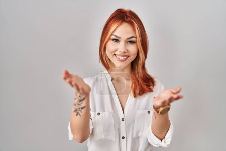 Téléchargez les photos : Jeune femme caucasienne debout sur fond isolé souriant joyeuse offrant les mains donnant de l'aide et l'acceptation. - en image libre de droit