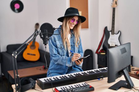 Téléchargez les photos : Jeune musicienne souriante confiante compositeur chanson au studio de musique - en image libre de droit