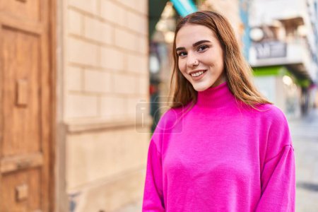 Téléchargez les photos : Jeune femme souriant confiant debout dans la rue - en image libre de droit