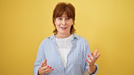 Téléchargez les photos : Femme d'âge moyen souriant confiant parlant sur fond jaune isolé - en image libre de droit