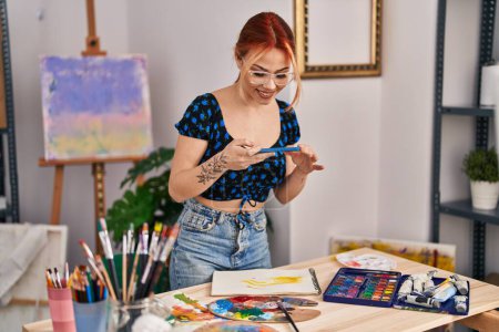 Téléchargez les photos : Jeune femme caucasienne artiste souriant confiant faire une photo pour dessiner au studio d'art - en image libre de droit