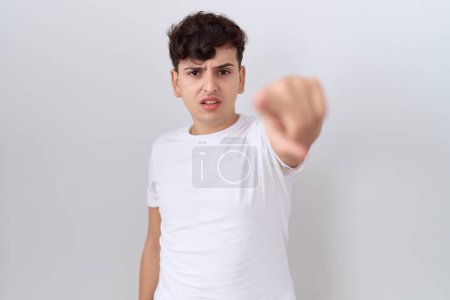 Foto de Joven hombre no binario con camiseta blanca casual señalando disgustado y frustrado a la cámara, enojado y furioso con usted - Imagen libre de derechos