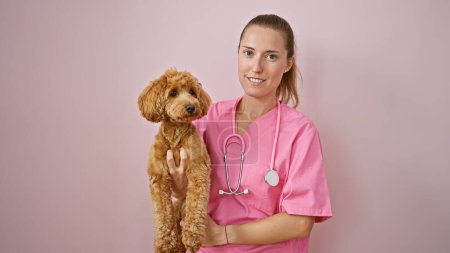 Photo for Young caucasian woman with dog veterinarian smiling confident holding dog over isolated pink background - Royalty Free Image