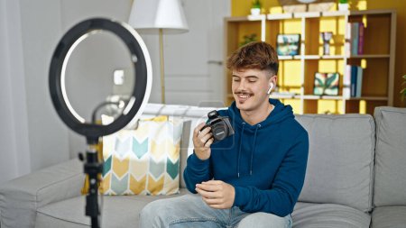 Téléchargez les photos : Jeune homme hispanique photographe enregistrement photo tutoriel vidéo à la maison - en image libre de droit