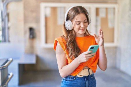 Young woman smiling confident listening to music at university