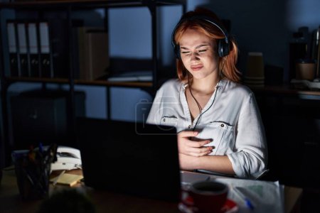 Téléchargez les photos : Young caucasian woman working at the office at night with hand on stomach because nausea, painful disease feeling unwell. ache concept. - en image libre de droit