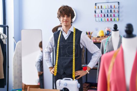 Photo for Young blond man tailor smiling confident standing at clothing factory - Royalty Free Image