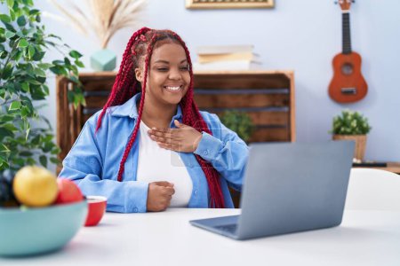 Téléchargez les photos : Femme afro-américaine utilisant un ordinateur portable communiquer avec la langue sourde à la maison - en image libre de droit