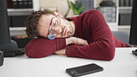 Téléchargez les photos : Jeune homme hispanique homme d'affaires fatigué dormir sur la table au bureau - en image libre de droit