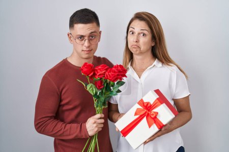 Photo for Mother and son holding mothers day gift skeptic and nervous, frowning upset because of problem. negative person. - Royalty Free Image