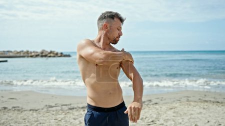 Photo for Young man tourist applying sunscreen at the beach - Royalty Free Image