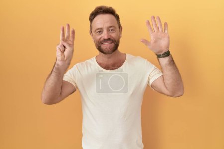 Téléchargez les photos : Homme d'âge moyen avec barbe debout sur fond jaune montrant et pointant vers le haut avec les doigts numéro huit tout en souriant confiant et heureux. - en image libre de droit