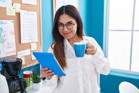 Photo for Young beautiful arab woman business worker using touchpad drinking coffee at office - Royalty Free Image
