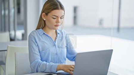 Foto de Mujer joven rubia trabajadora de negocios usando laptop trabajando en la oficina - Imagen libre de derechos