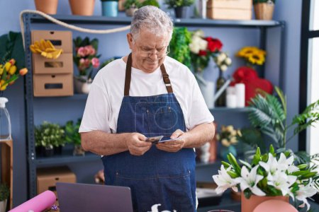 Photo for Middle age grey-haired man florist smiling confident counting dollars at florist - Royalty Free Image