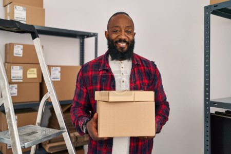 Foto de Hombre afroamericano que trabaja en el comercio electrónico de pequeñas empresas sonriendo con una sonrisa feliz y fresca en la cara. mostrando dientes. - Imagen libre de derechos