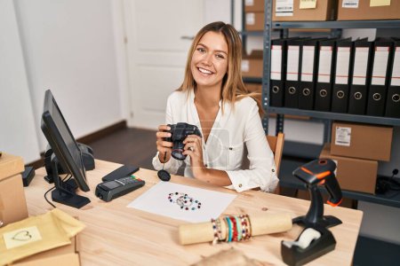 Téléchargez les photos : Jeune femme hispanique ecommerce travailleur d'affaires faire une photo au bracelet au bureau - en image libre de droit