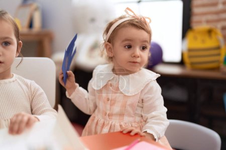 Photo for Two little girls drawing on notebook sitting on table at kindergarten - Royalty Free Image