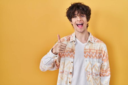 Photo for Young man wearing casual summer shirt doing happy thumbs up gesture with hand. approving expression looking at the camera showing success. - Royalty Free Image