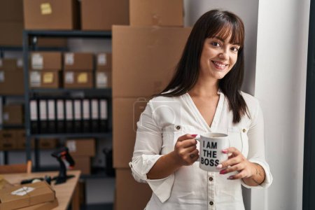 Photo for Young beautiful hispanic woman ecommerce business worker drinking coffee at office - Royalty Free Image
