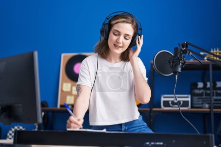 Téléchargez les photos : Young woman musician composing song at music studio - en image libre de droit