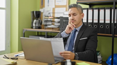 Photo for Young hispanic man business worker reading letter thinking at office - Royalty Free Image