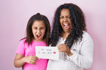 Photo for Mother and young daughter holding my mom is the best banner angry and mad screaming frustrated and furious, shouting with anger. rage and aggressive concept. - Royalty Free Image