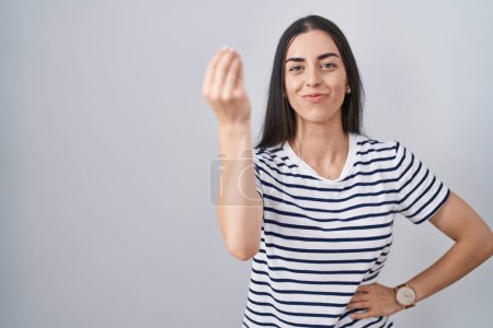 Téléchargez les photos : Jeune femme brune portant t-shirt rayé faisant geste italien avec la main et les doigts expression confiante - en image libre de droit