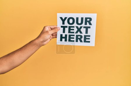 Foto de Mano de hombre caucásico sosteniendo papel con su mensaje de texto aquí sobre fondo blanco aislado - Imagen libre de derechos