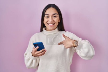 Photo for Young south asian woman using smartphone pointing finger to one self smiling happy and proud - Royalty Free Image