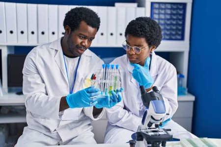 Foto de Científicos afroamericanos sosteniendo tubos de ensayo en laboratorio - Imagen libre de derechos