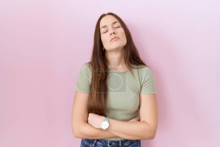 Photo for Beautiful brunette woman standing over pink background looking sleepy and tired, exhausted for fatigue and hangover, lazy eyes in the morning. - Royalty Free Image