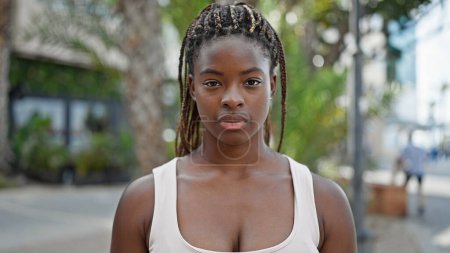 Foto de Mujer afroamericana de pie con expresión seria en el parque - Imagen libre de derechos
