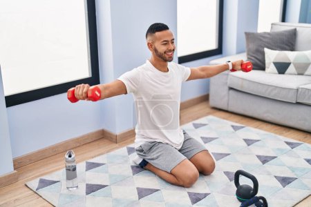 Photo for African american man smiling confident using dumbbells training at home - Royalty Free Image